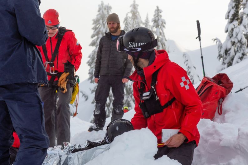 Cestovní pojištění na lyže: horská služba zasahující u zraněného lyžaře