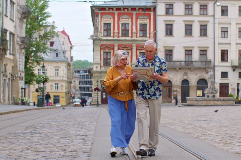 Penzijní připojištění a odpočet daně v roce 2022: pár starších turistů s mapou prochází městem.