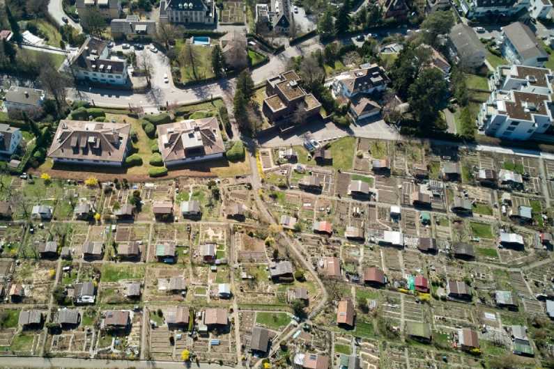 Letecký pohled na část města s domy a zahrádkami.